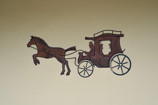 Illustration of horse carriage at facade outside of post office at City of Skofja Loka on a cloudy summer day. Photo taken August 9th, 2023, Skofja Loka, Slovenia.