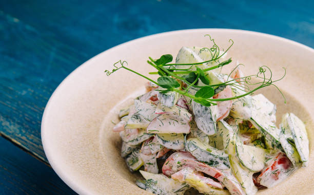 istock Salad with fresh vegetables and cream sause on plate 2057937307