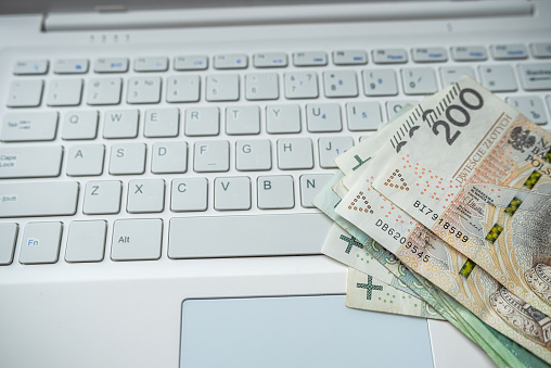 Pln 200 zloty Polish money on laptop keyboard, finance saving concept