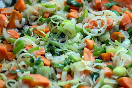 chopped carrots and leeks in a frying pan