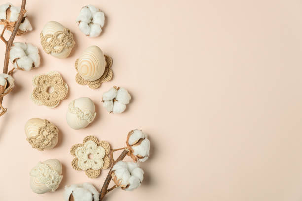 istock Craft eggs, knitted and cotton flowers on soft beige background. Top view. Copy space 2057964267