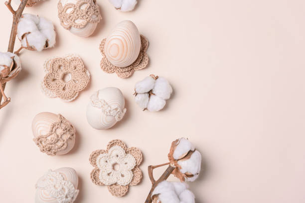 istock Craft eggs, knitted and cotton flowers on soft beige background. Top view. Copy space 2057964271