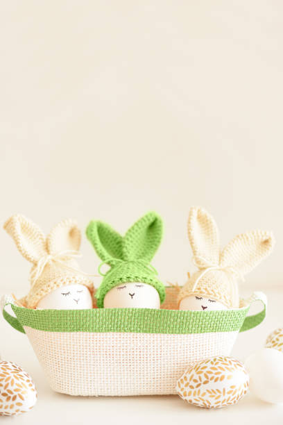 istock Easter eggs in crochet knitted hats with rabbit ears in nest. Easter celebration concept 2057964821