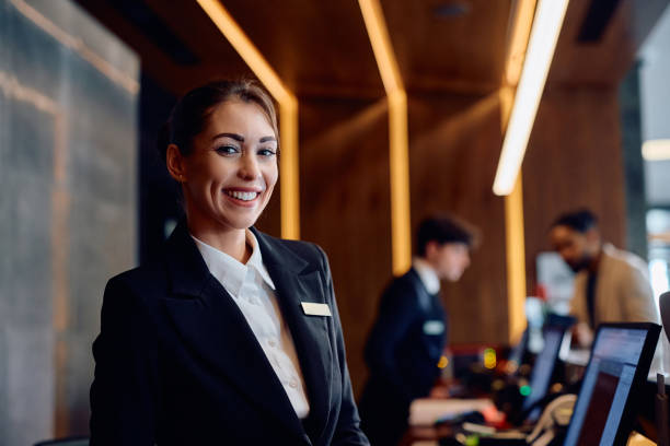 istock Happy female concierge at front desk in a hotel looking at camera. 2057971950