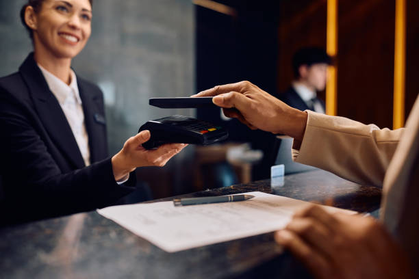 istock Close up of black man using smart phone while paying in a hotel. 2057973045