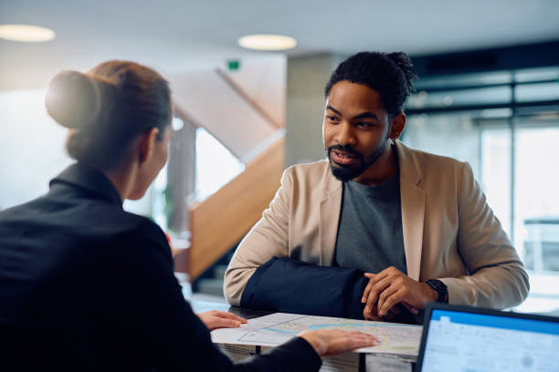 istock African American man communicating with receptions at hotels front desk. 2057973585