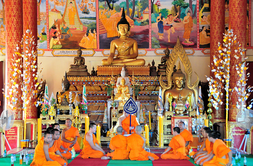 Vientiane, Laos: Wat That Luang Neua, temple on That Luang Park, Pha That Luang complex, Ban Thatluang. Monks during a Buddhist service in the congregation hall (sim), with the main Buddha altar in the background.