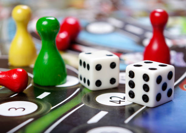 istock colorful play figures with dice on board 2057996276