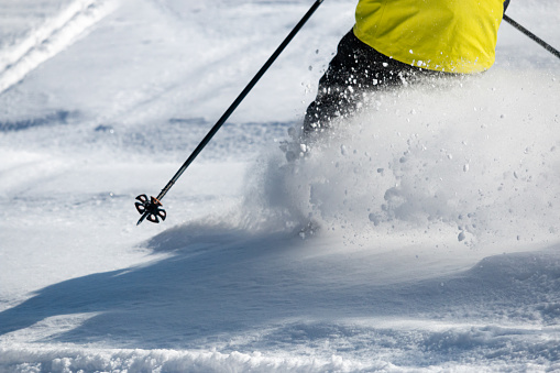 Powder snow flying up behind male skier, Hokkaido