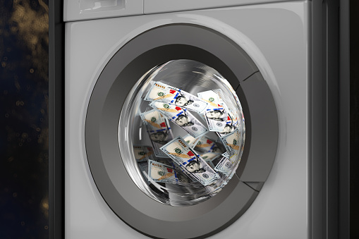 Money Laundering with a Washing Machine Filled with US Dollar Bills. 3D Render