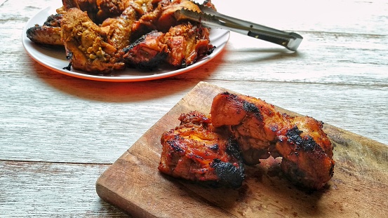 Grilling marinated chicken on charcoal outdoor grills.