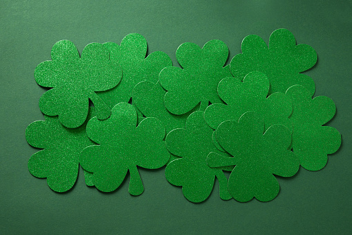 Happy St. Patrick's day clover leaves on green background. Flat lay. View from above. Greeting card.