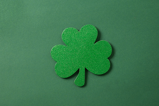 St. Patrick's day clover leaf isolated on green background. View from above. Copy space.
