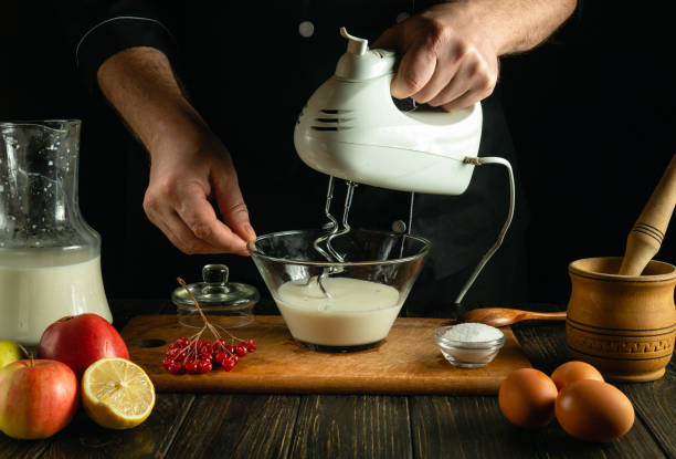 istock Chef prepares an egg omelette with milk using a hand-held electric mixer. Concept of preparing delicious breakfast in restaurant kitchen 2058033624