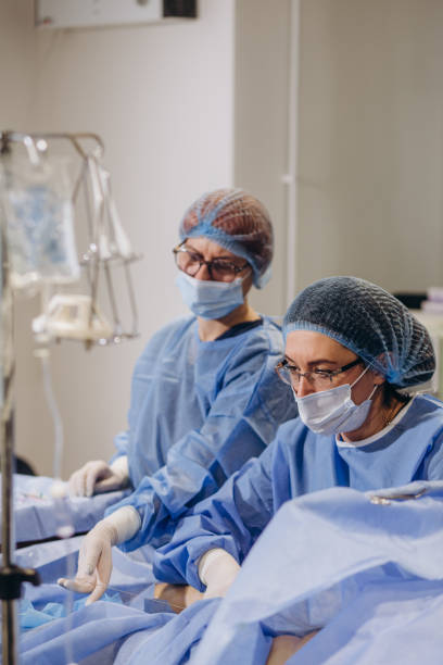 istock Team of surgeon in uniform perform varicose veins correction operation on a patient at surgery clinic. phlebology. 2058047313