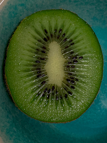 Kiwi fruit on a green plate. Close-up.