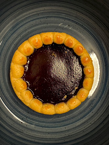 Close-up of a cherry jam pie on a blue plate,