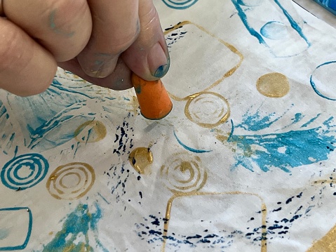 Making marks with paint onto fabric.