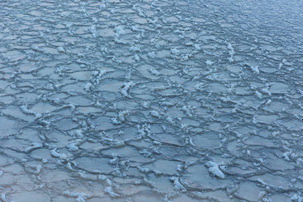 A beautiful cracked ice patterns on the frozen lake surface during winter in Latva. Cold scenery of Northern Europe.
