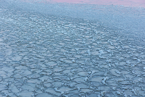 A beautiful cracked ice patterns on the frozen lake surface during winter in Latva. Cold scenery of Northern Europe.
