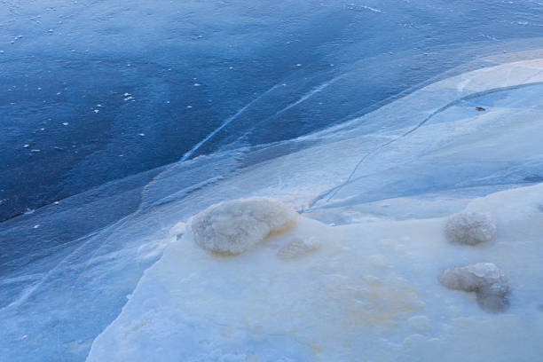 A beautiful cracked ice patterns on the frozen lake surface during winter in Latva. Cold scenery of Northern Europe.