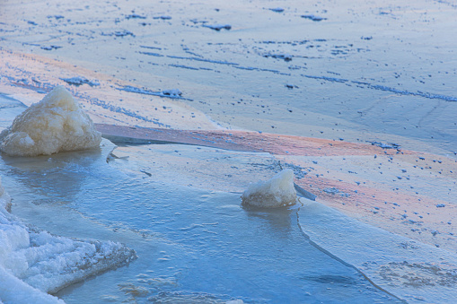 A beautiful cracked ice patterns on the frozen lake surface during winter in Latva. Cold scenery of Northern Europe.