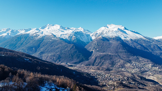 Aerial view of winter landscape with mountain peaks covered with snow in the italian Alps. Natural background.