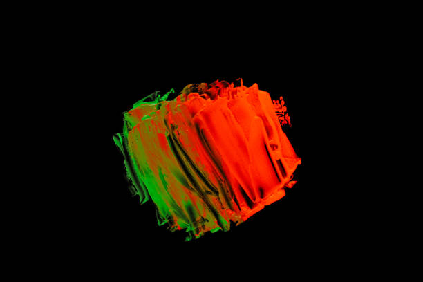 Neon green orange color paint splotches on black background. Isolated design element