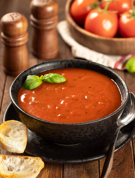 istock Bowl of tomato soup garnished with basil leaves 2058125737