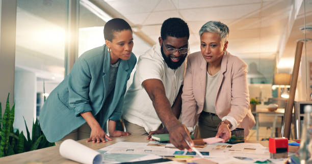 istock Discussion, planning and business people in office at night for a creative project with paperwork. Meeting, diversity and team of designers working overtime on research in collaboration for deadline. 2058134346