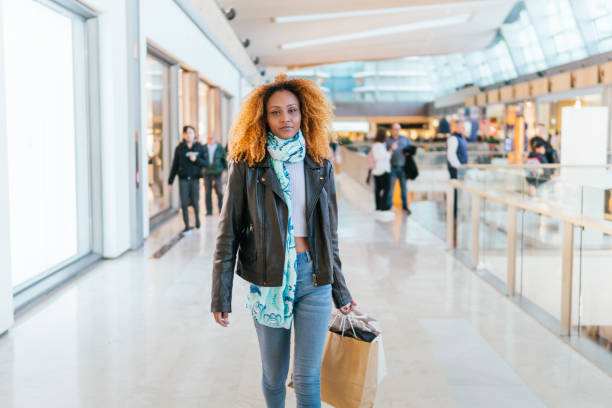 istock Black woman walks through a mall 2058135923