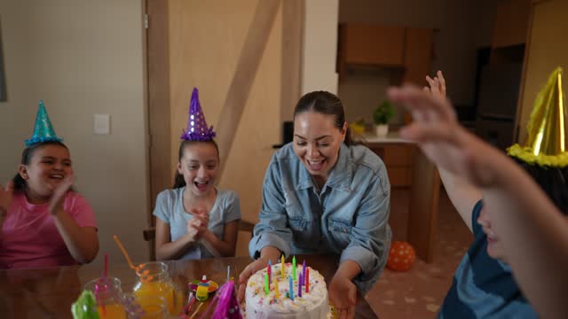Mid adult woman arriving with cake to celebrate son birthday at home