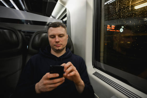 istock front view portrait of a man using mobile train in midnight train. 2058159659