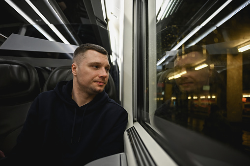 Tired Businessman looking out of the window of train.