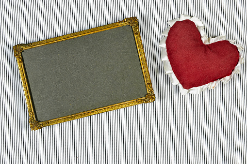 empty golden picture or photo frame mockup  with Valentines or women's day heart toy on lines background