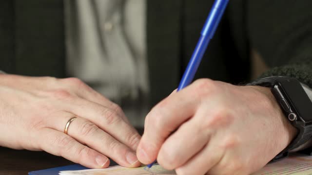 Man signing divorce document and taking off ring