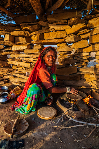 Indian woman preparing food - chapati, flatbread, desert village, India.