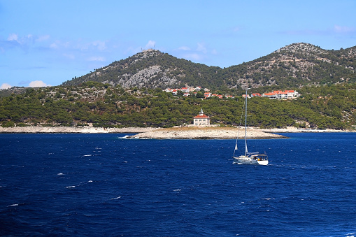 Sailing boat and picturesque lighthouse near town Hvar, on island Hvar, Croatia.