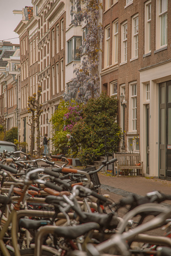 Bicycle handlebars of hundreds of bicycles wheels parked in a street of Amsterdam in Holland