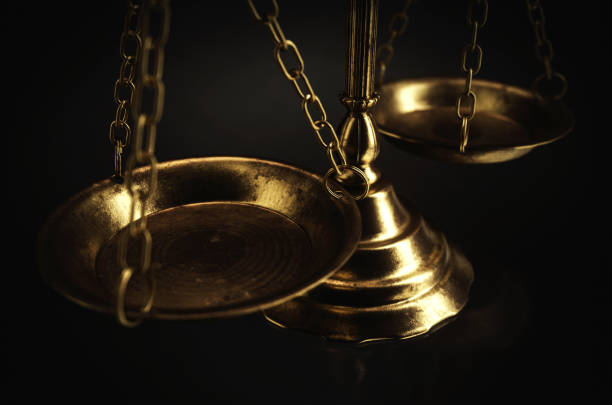 Ornate brass justice scales on a dark isolated background - 3D render