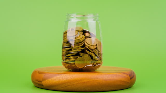 Saving coins in a glass jar increases the amount of money quickly. Financial planning and investments financial growth