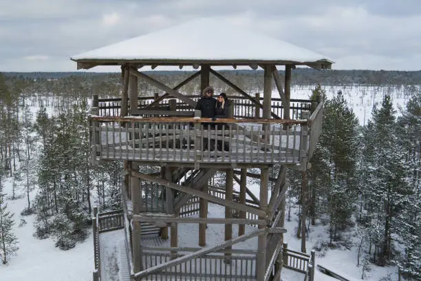 Photo of Young couplein winter on an observation tower on the Viru swamp. Drone photo.