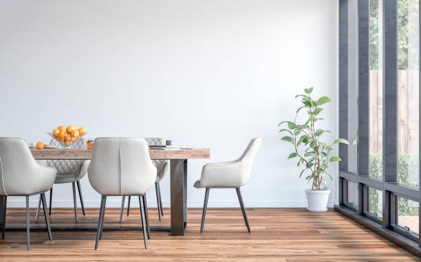 a side view of a modern dining room with a dining table and chairs, a garden view through windows in the background - sala de jantar imagens e fotografias de stock