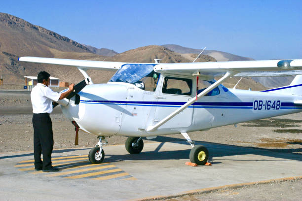 Nazca, Peru.  May 22nd 2006.  A pilot preparing a small plane at the airport in Nazca to take tourists on a flight to view the famous Nazca Lines in the desert.