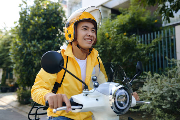 Delivery Man Riding Scooter Smiling Vietnamese delivery man riding scooter vietnamese man taxi motorbike driver stock pictures, royalty-free photos & images