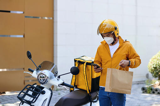 Courier in mask checking address of customer in mobile application