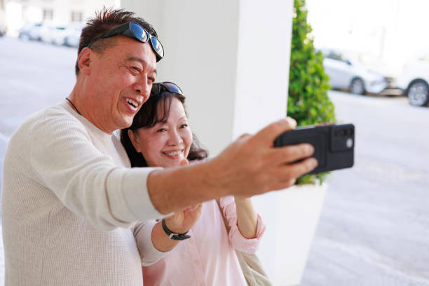 istock The elderly Asian couple happily taking a selfie on their smartphone while exploring Georgetown, Penang. 2058260422