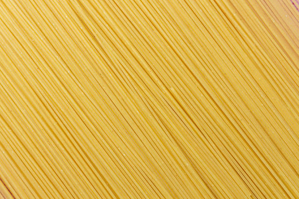 Yellow long spaghetti on a rustic background. Yellow italian pasta. Long spaghetti. Raw spaghetti bolognese. Italian food and menu concept.