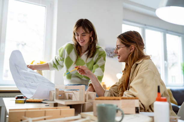 istock Two female architecture students making architectural model of a modern house 2058270494