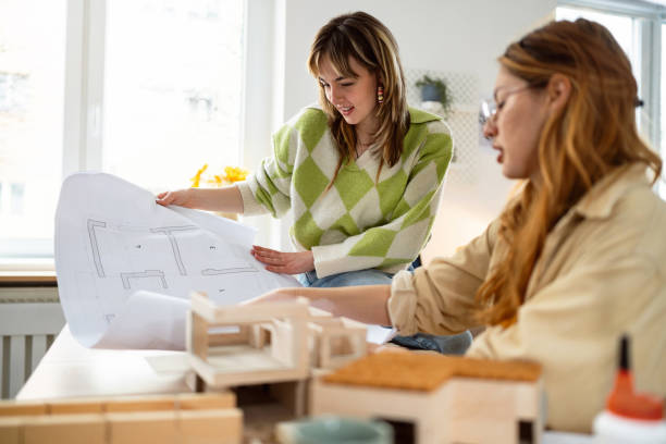 istock Two female architecture students making architectural model of a modern house 2058270509